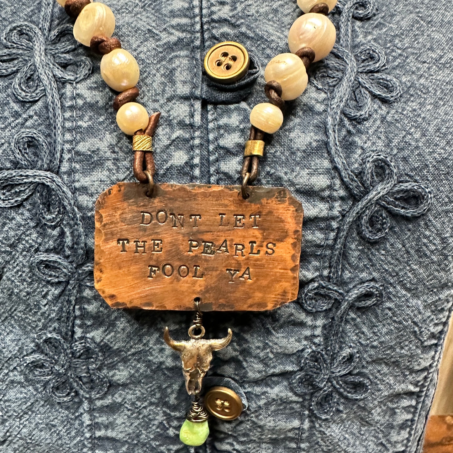 Necklace with text and bull skull pendant.