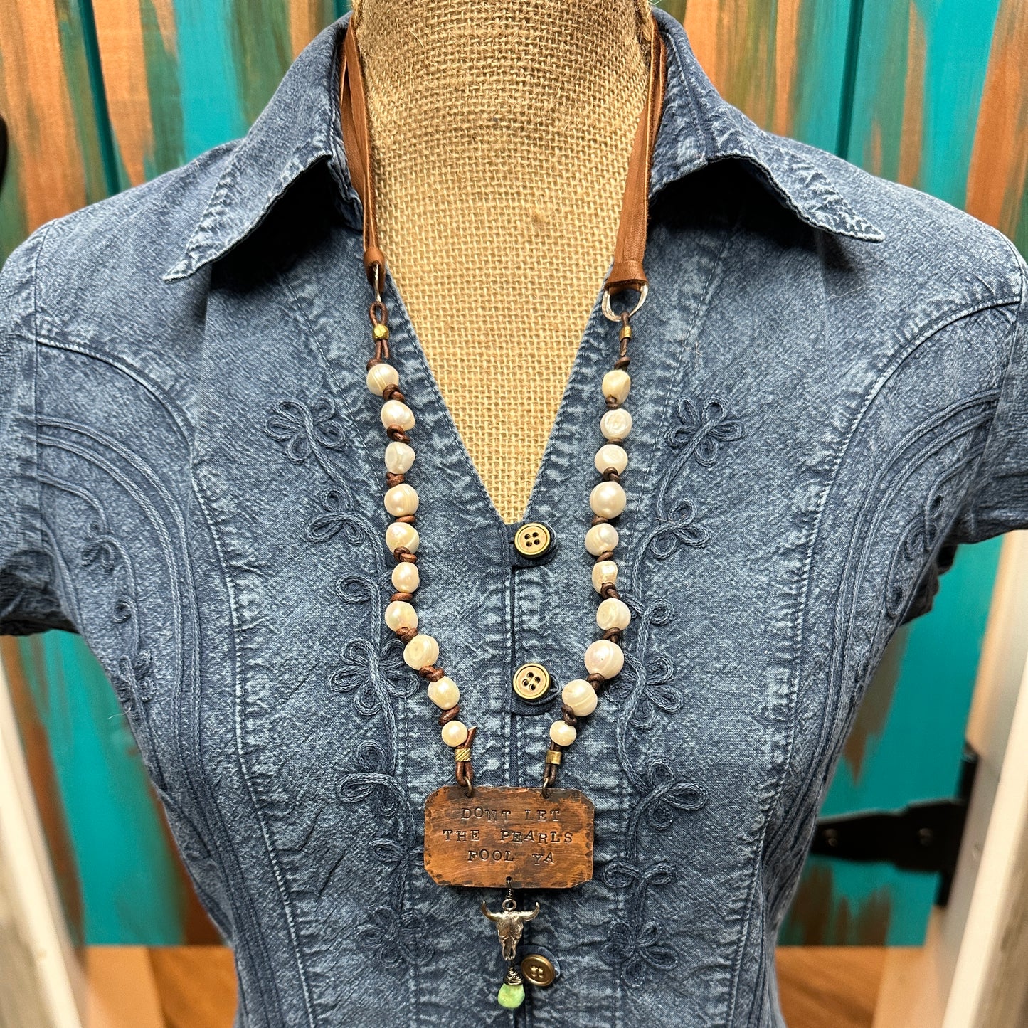 Necklace on a denim shirt.