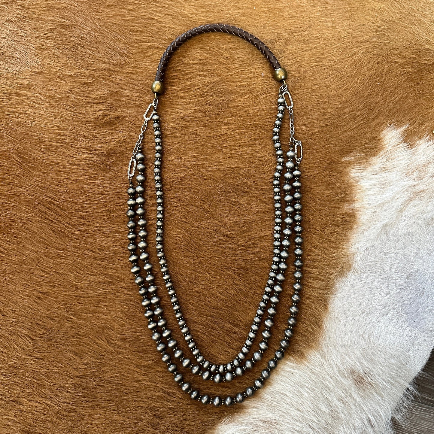 Three-strand beaded necklace on brown fur.