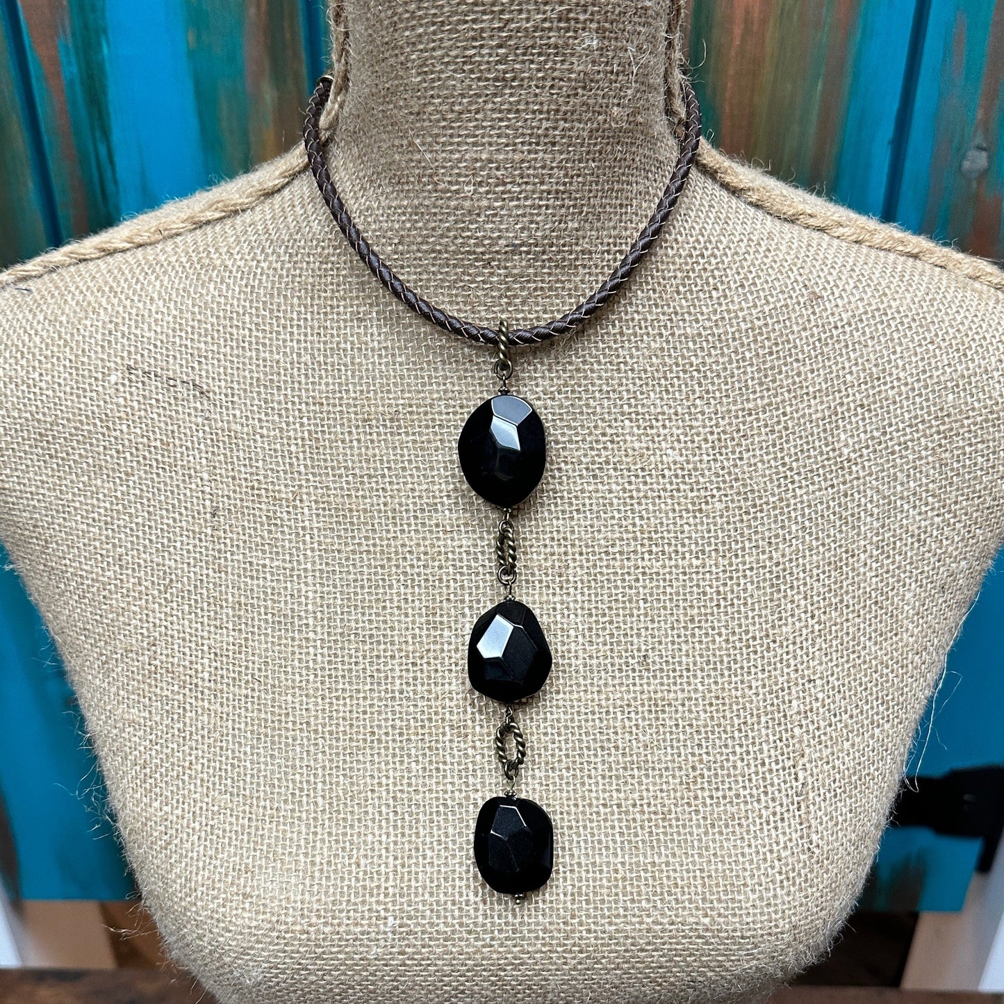 Black stone pendant necklace on a mannequin.