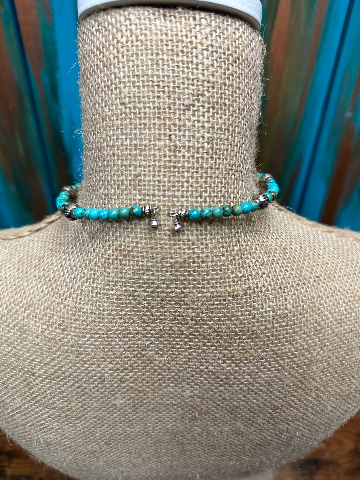 Turquoise beaded necklace on a bust.