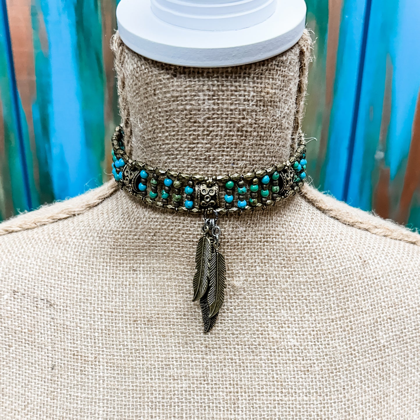 Beaded choker necklace with feather pendant.