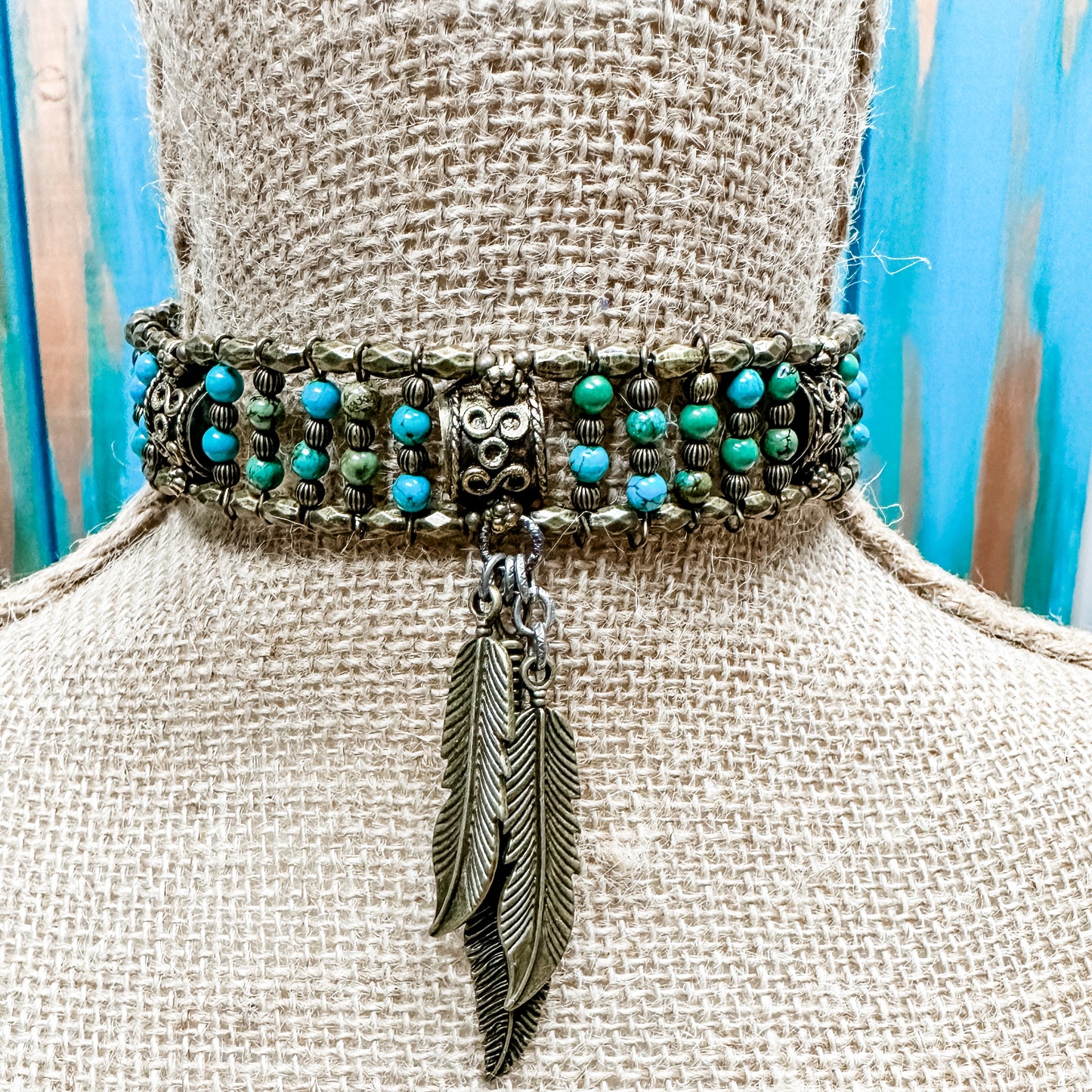 Choker necklace with turquoise beads and feather pendant.