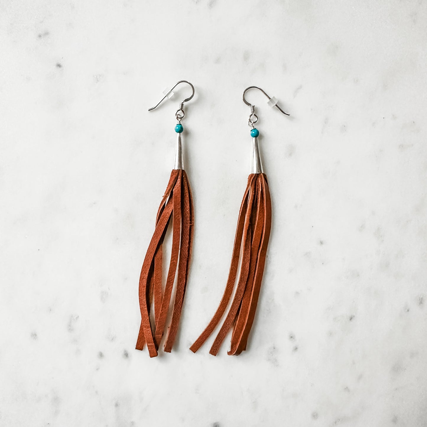 Leather tassel earrings with turquoise accents.