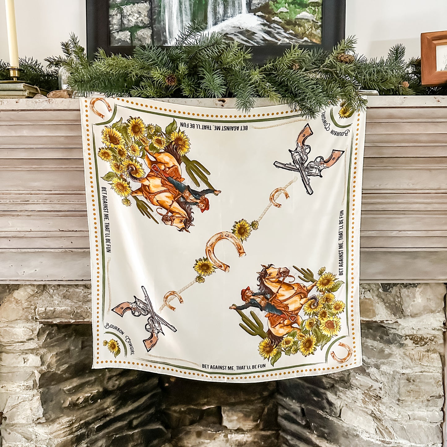 White scarf with cowboy art on a mantel.