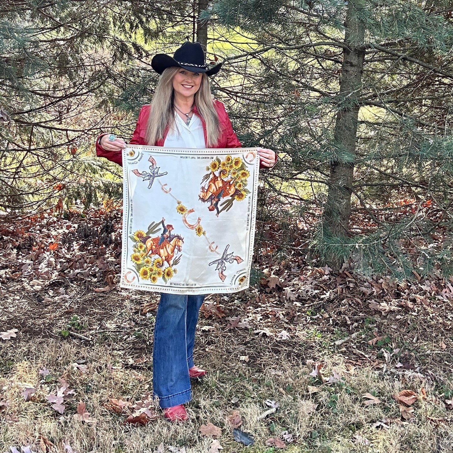 Woman in cowboy hat holding a scarf with horse and sunflower design.