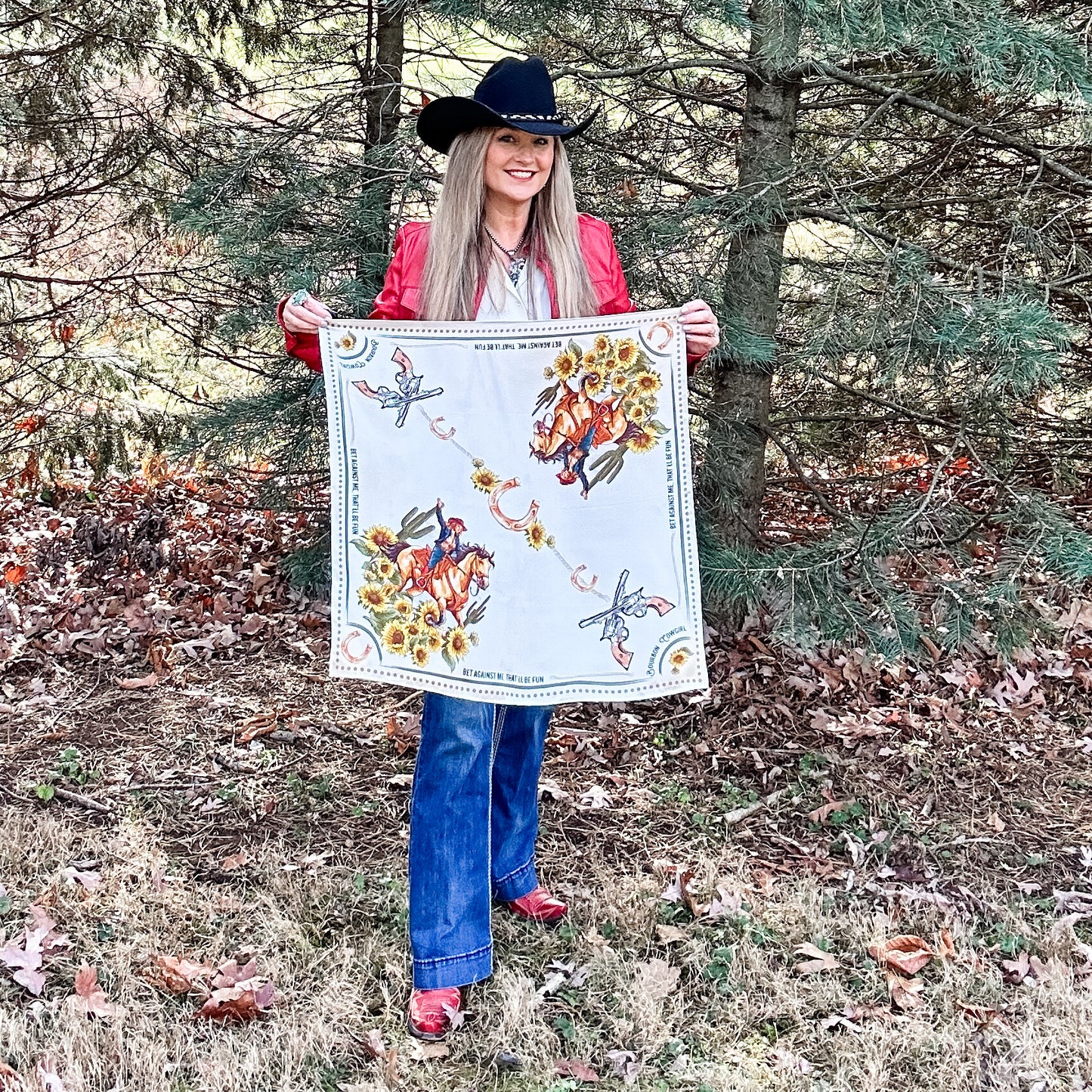 Woman in cowboy hat holding a patterned handkerchief.