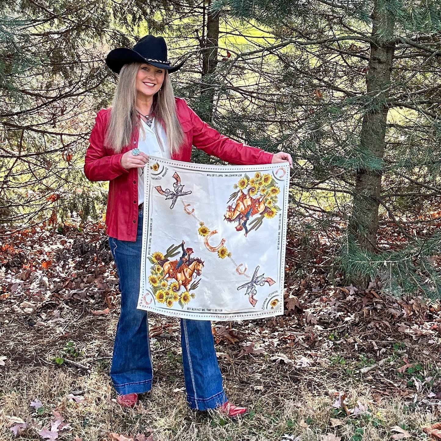 Woman in cowboy hat holding a bandana with illustrations.