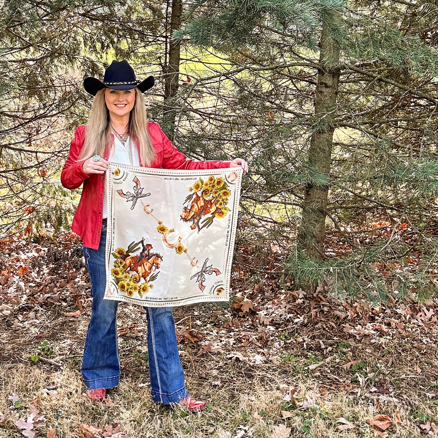 Woman in cowboy hat holding a scarf with floral design.