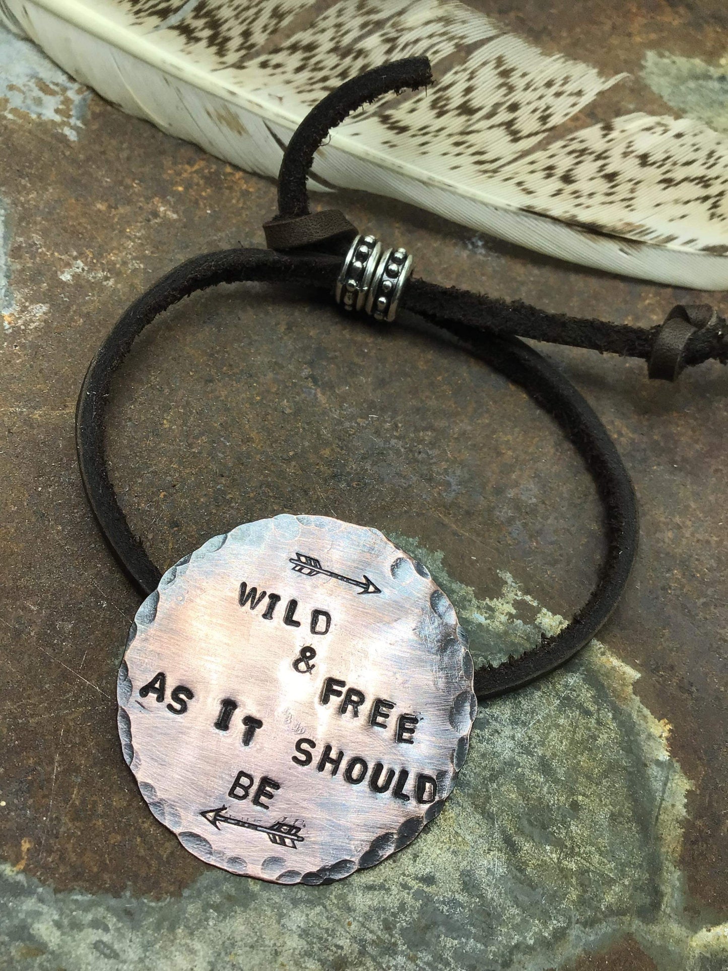 Leather bracelet with a copper charm.