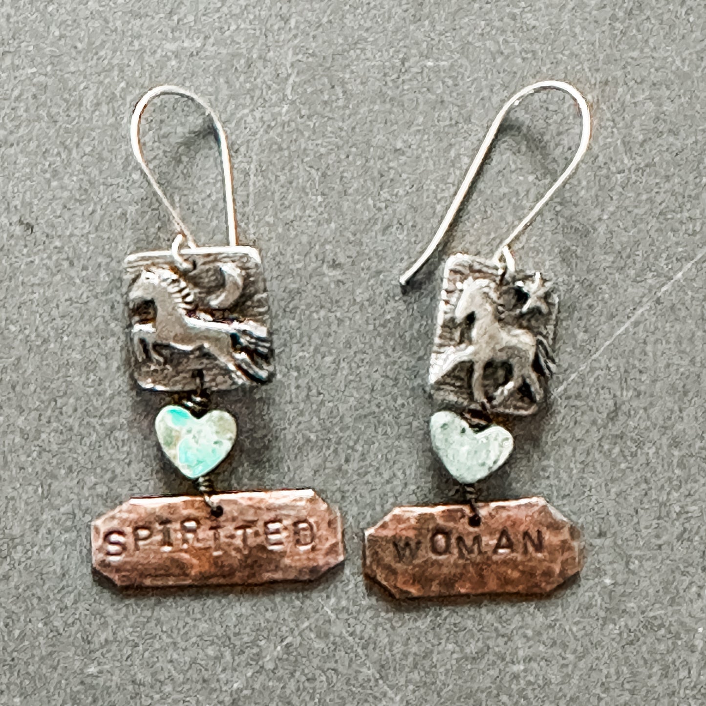 Silver earrings with horse, heart, and words.