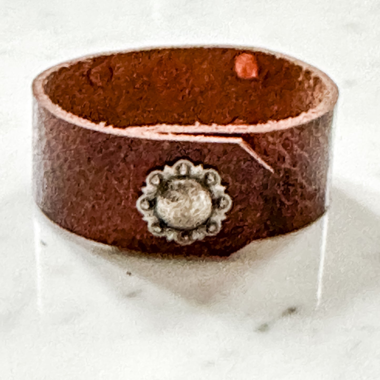 Brown leather cuff bracelet with silver embellishment.