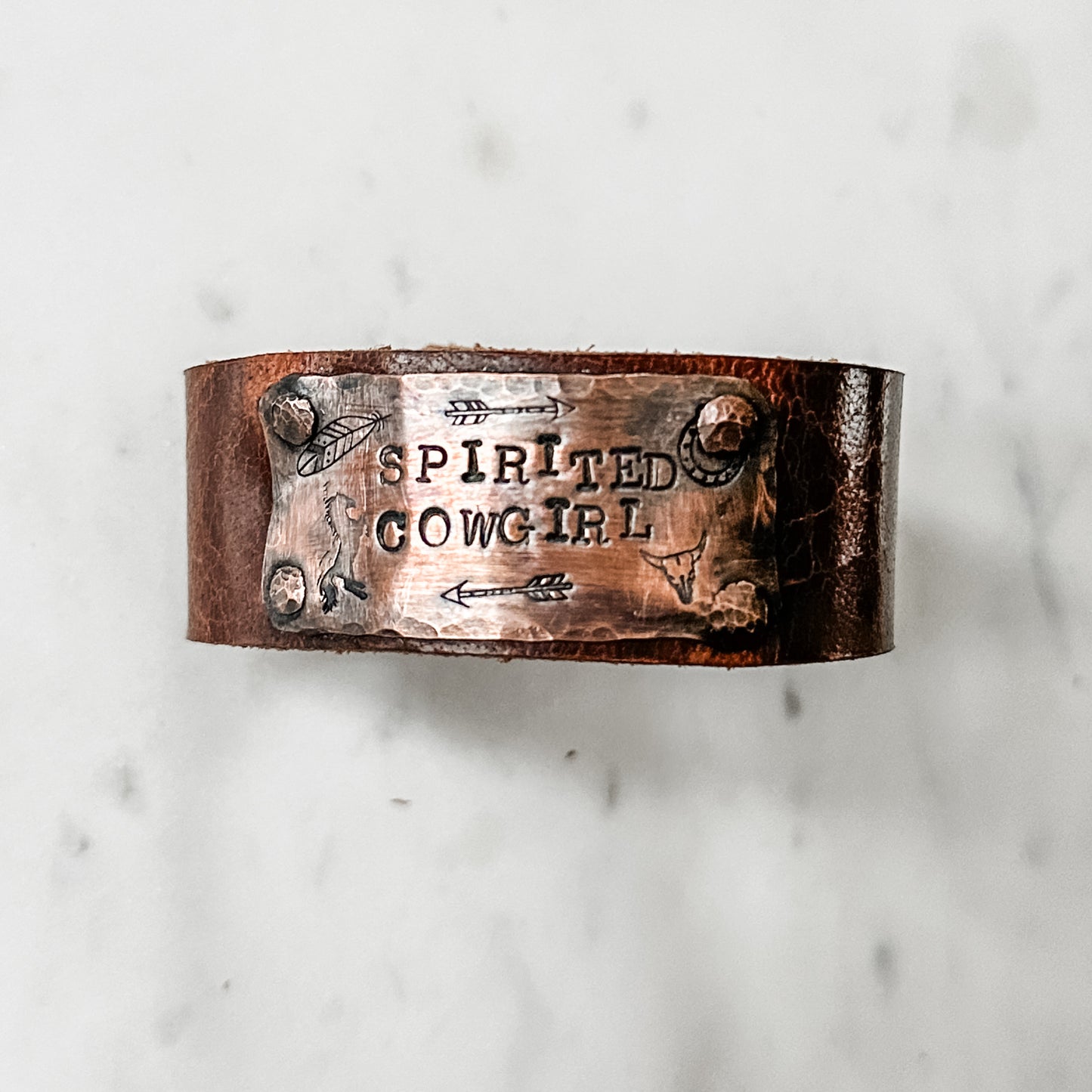 Leather bracelet with Spirited Cowgirl text.