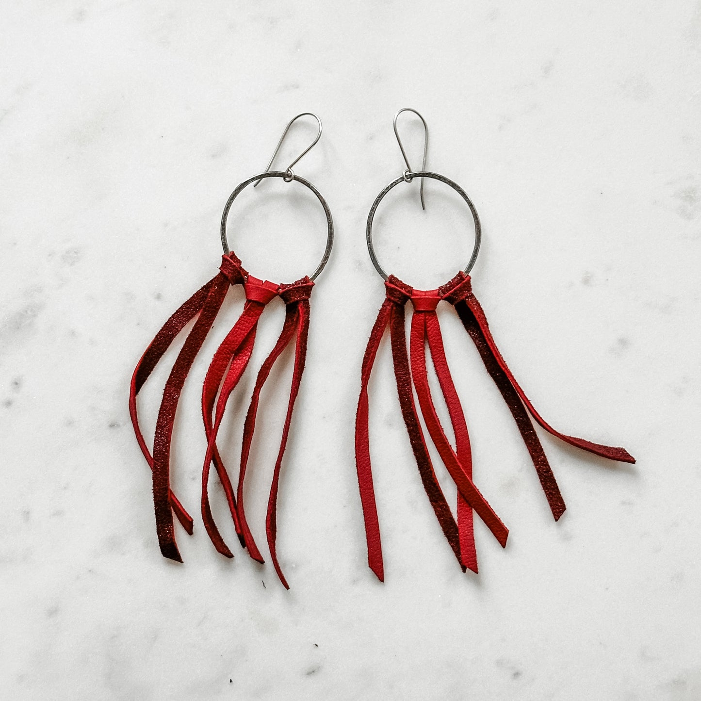 Two red leather fringe earrings.
