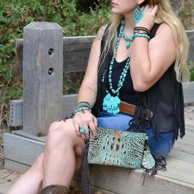Woman with JJ buckle, turquoise jewelry, and matching purse.