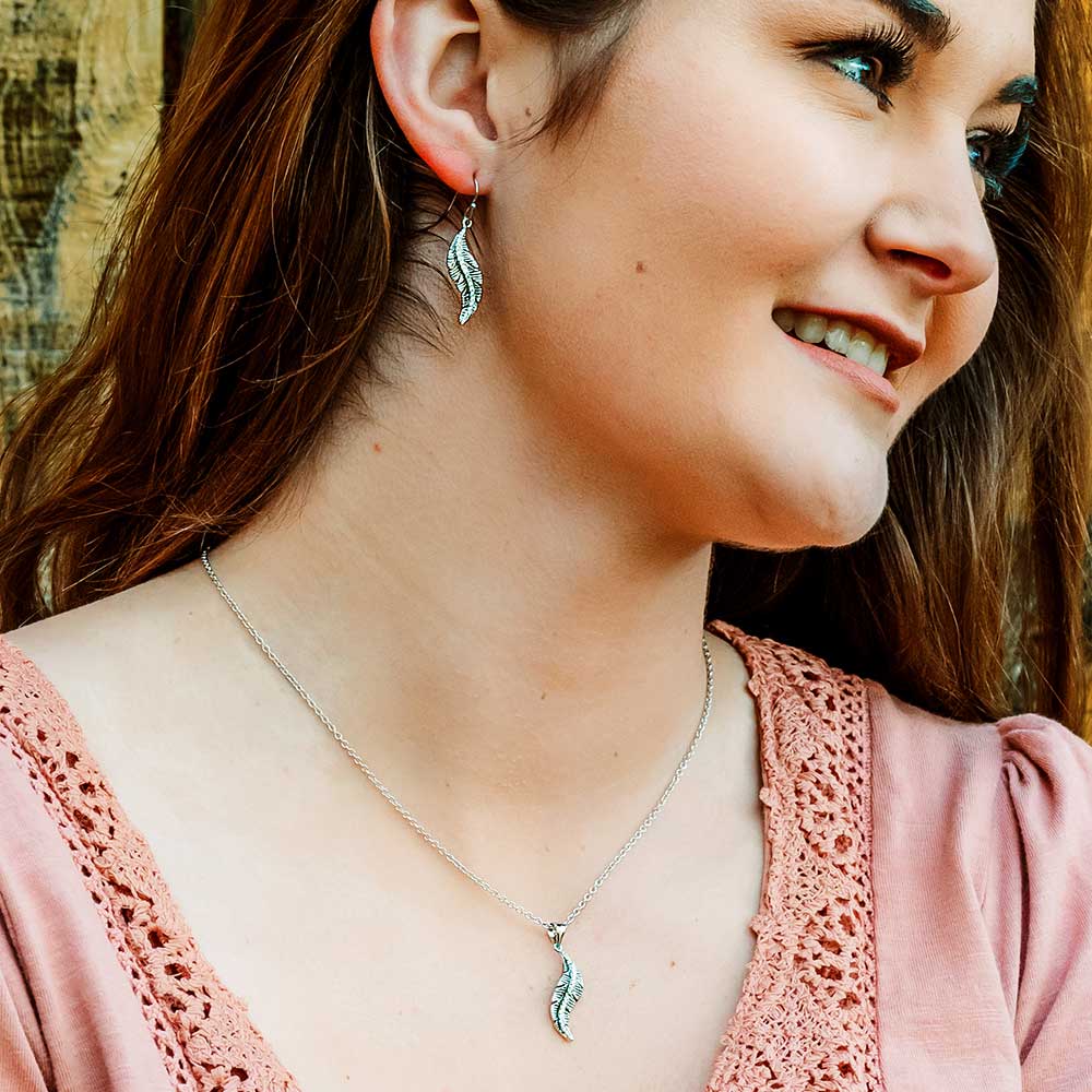 Woman wearing feather earrings & necklace