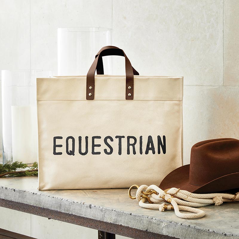 Equestrian tote bag with leather handles and hat.