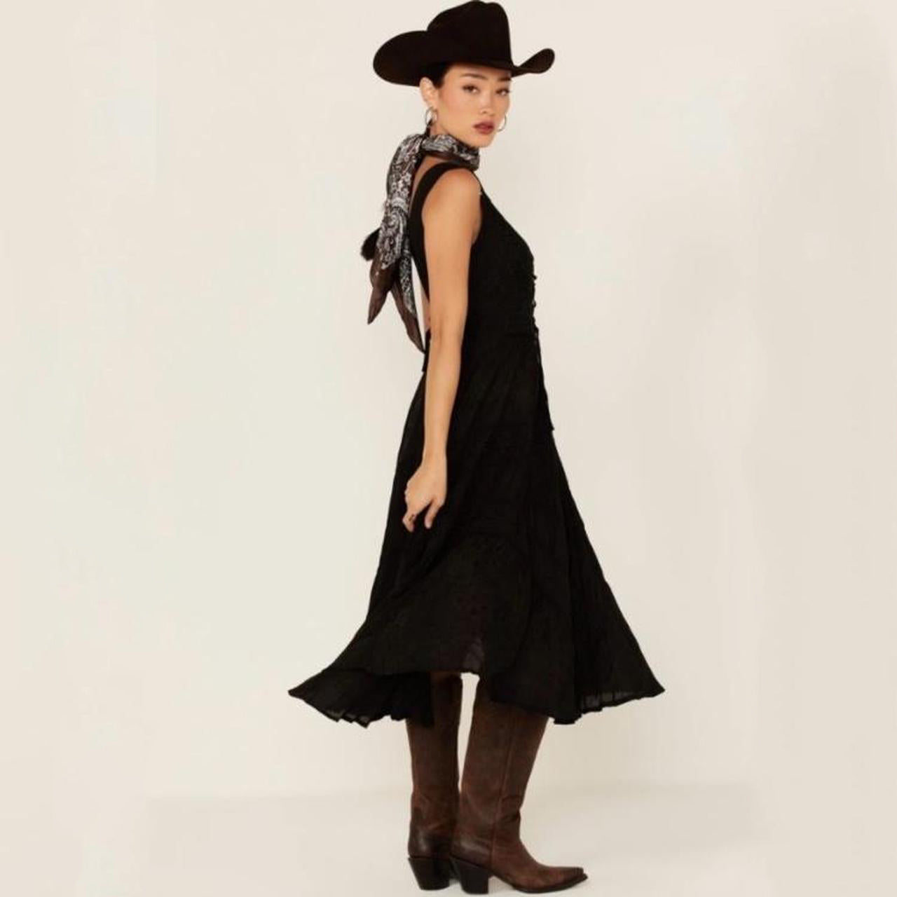 Woman in black dress, cowboy hat, and boots