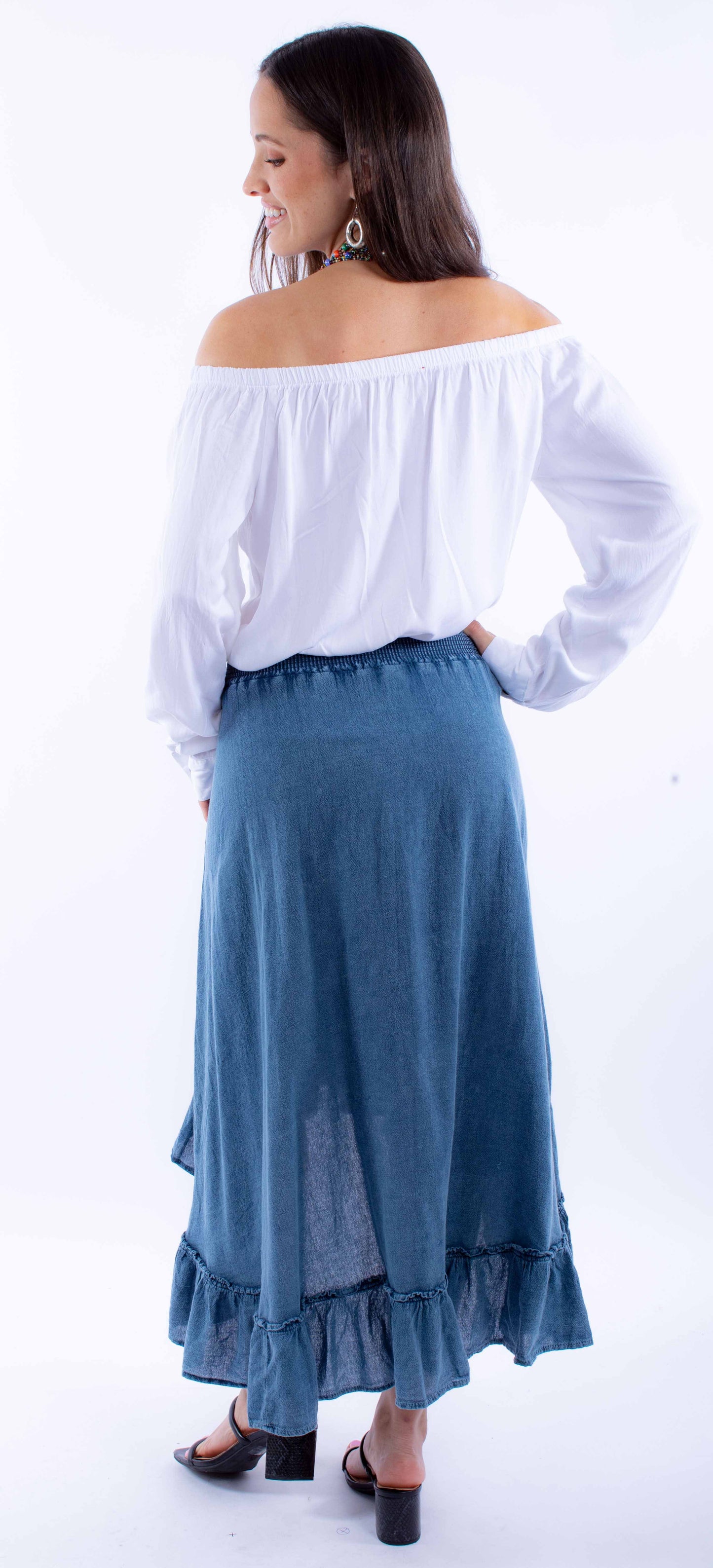 Woman in off-the-shoulder top and denim skirt.