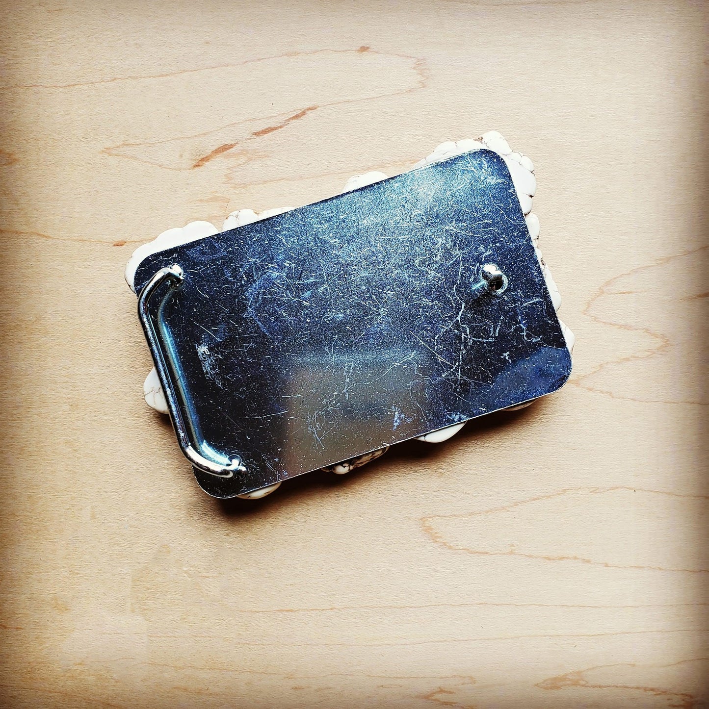 Metal belt buckle on wood surface