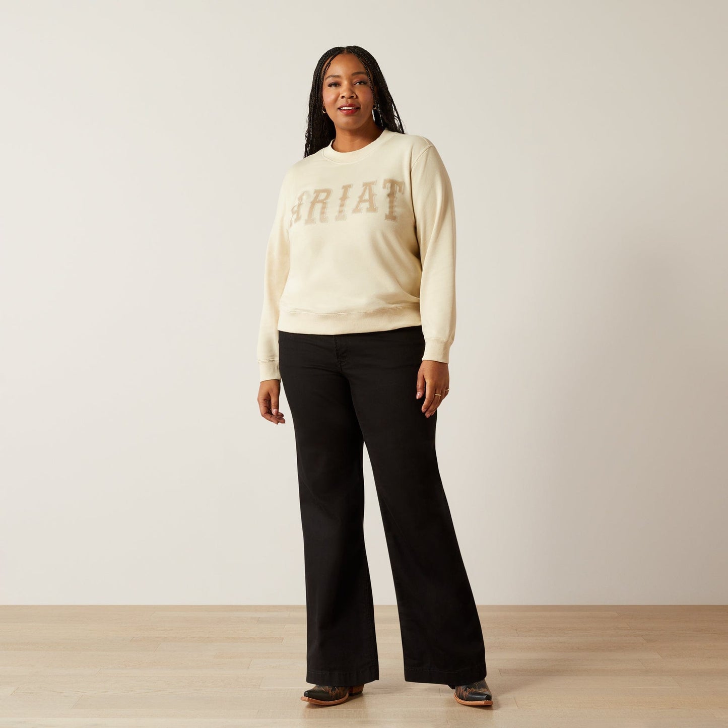 Woman wearing Ariat sweatshirt and black pants