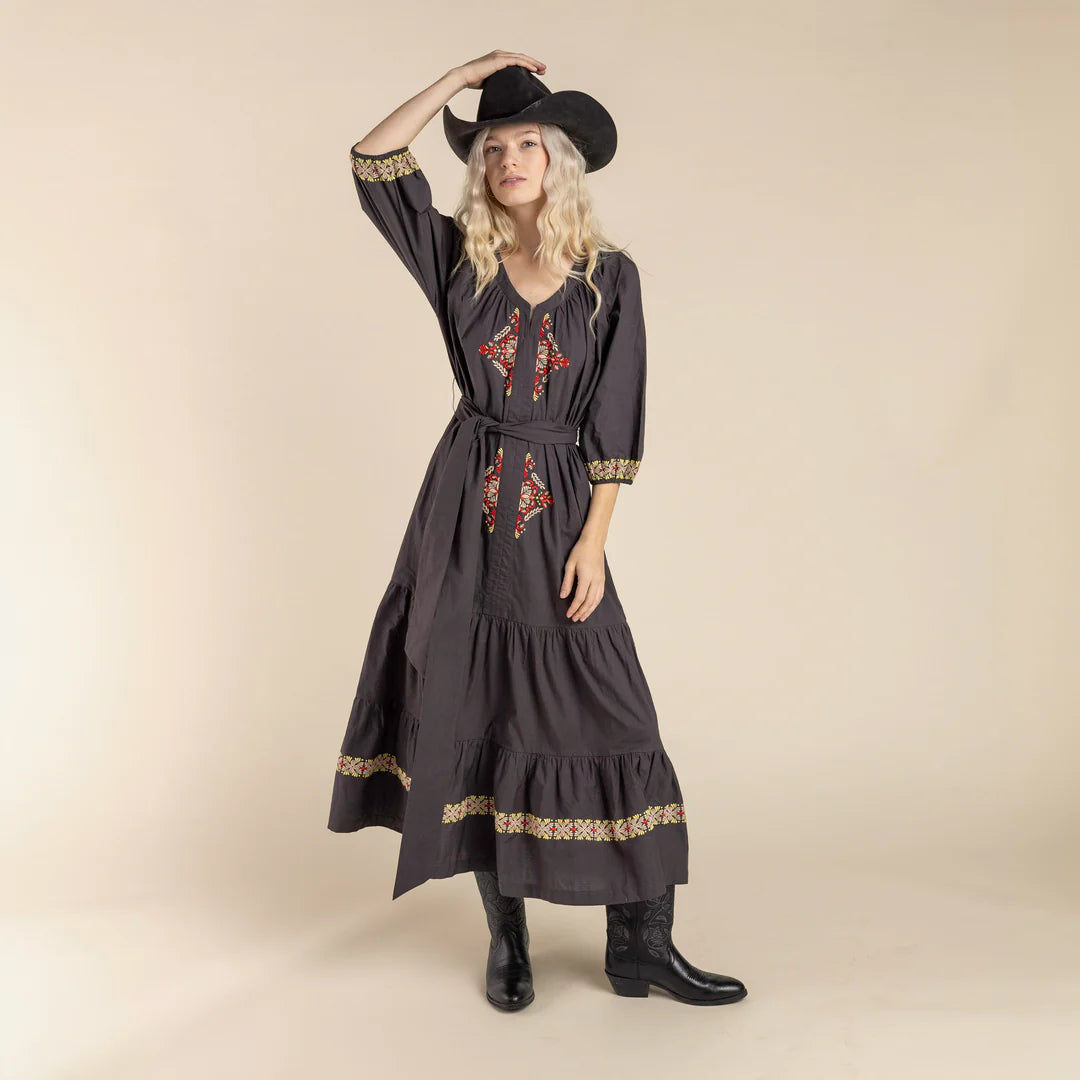 Woman in cowboy hat & embroidered dress.