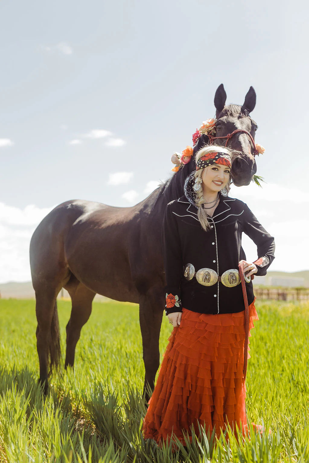 Woman and horse in western attire, wildflowers.