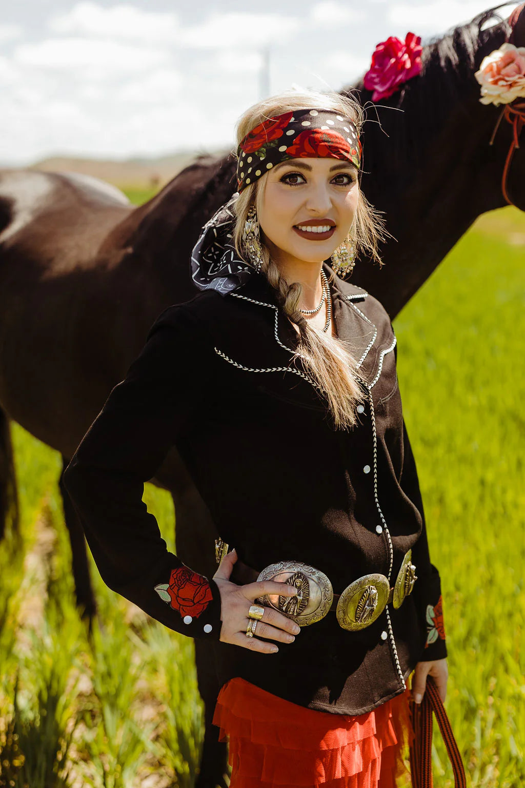 Woman in western wear with horse in field