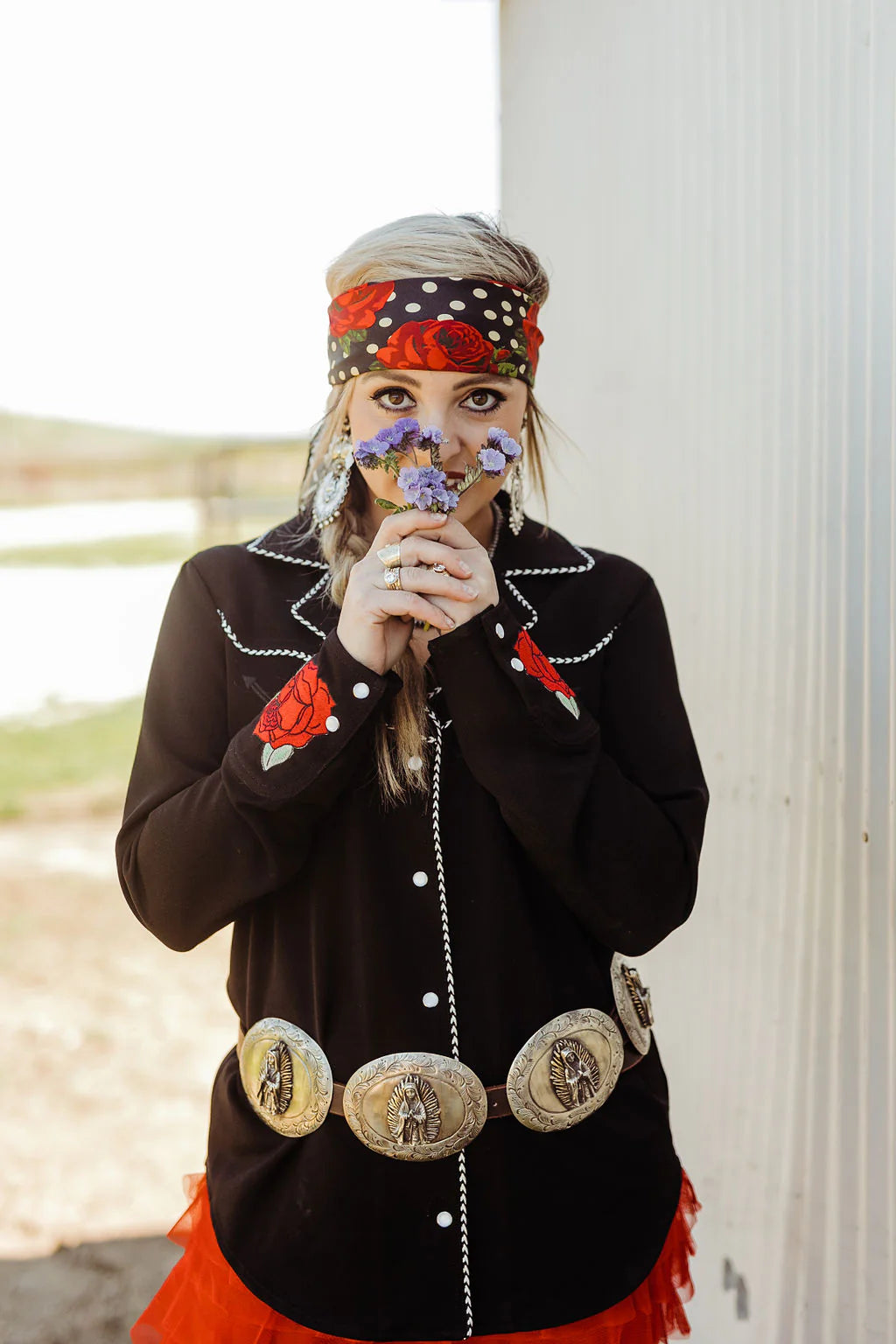 Woman smelling wildflowers, western style.