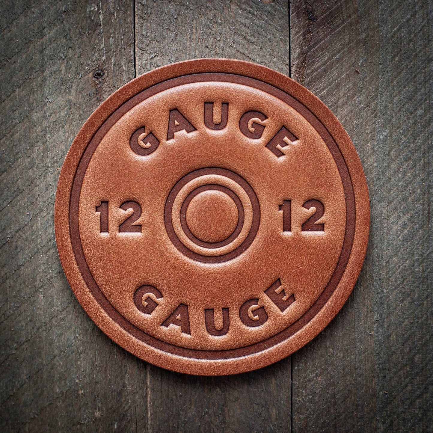 Brown leather coaster with GAUGE 12 text.