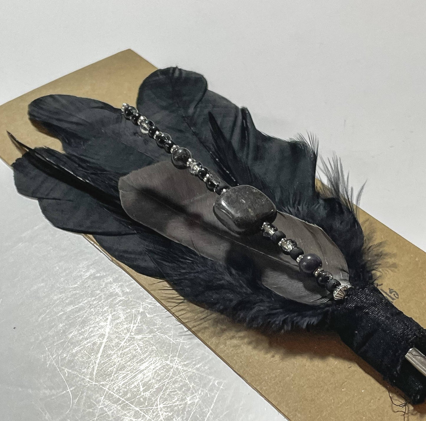 Black feather and bead hair clip.