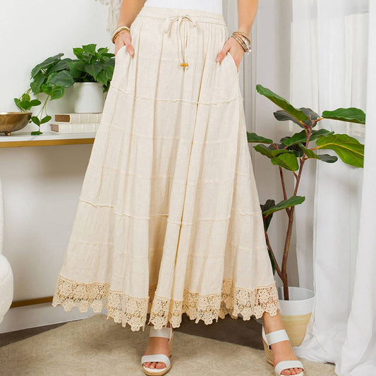 Woman wearing a long, cream-colored skirt.