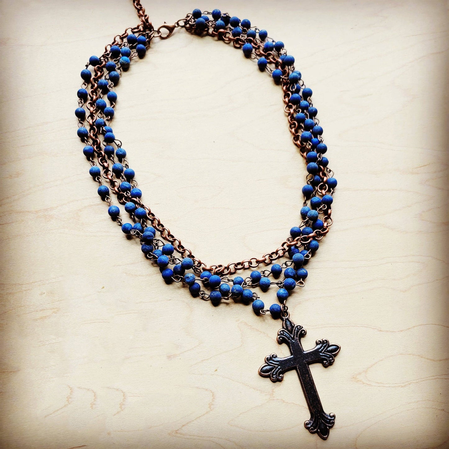 Blue beaded necklace with a cross pendant.