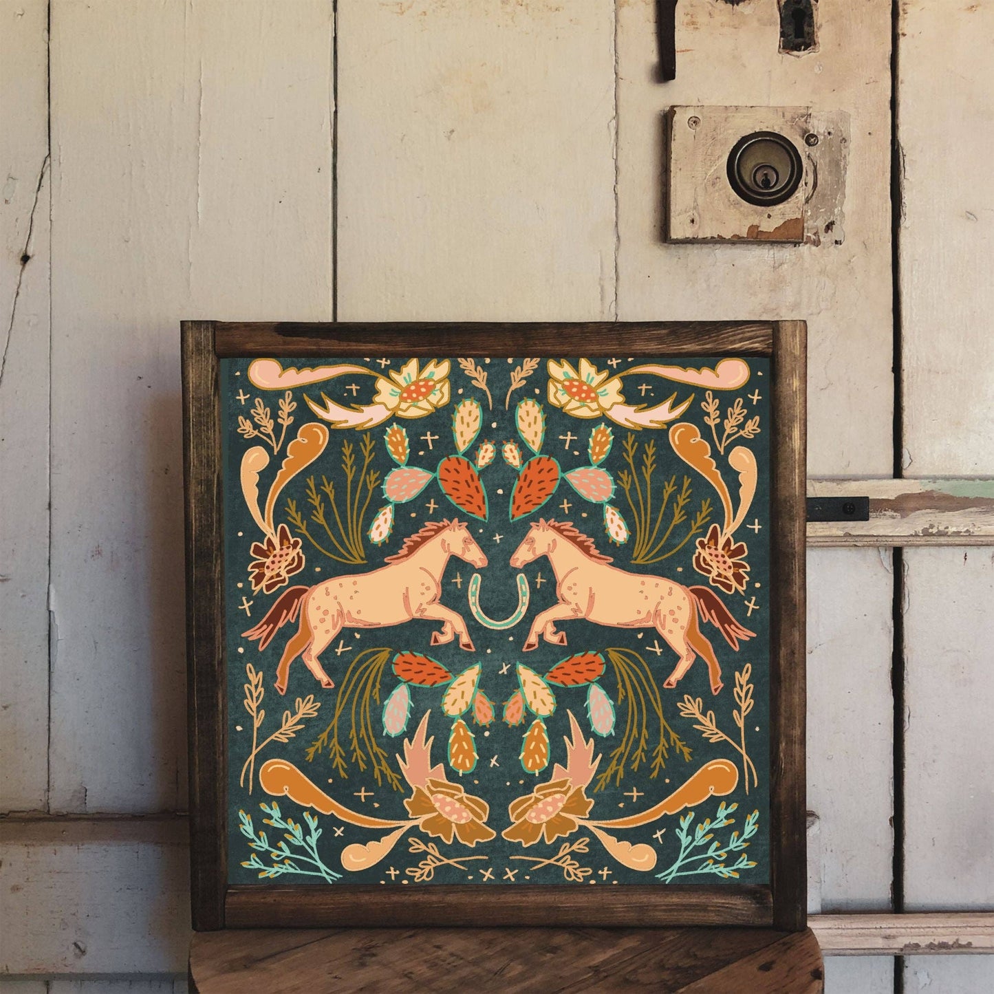 Framed artwork with two horses and floral design.