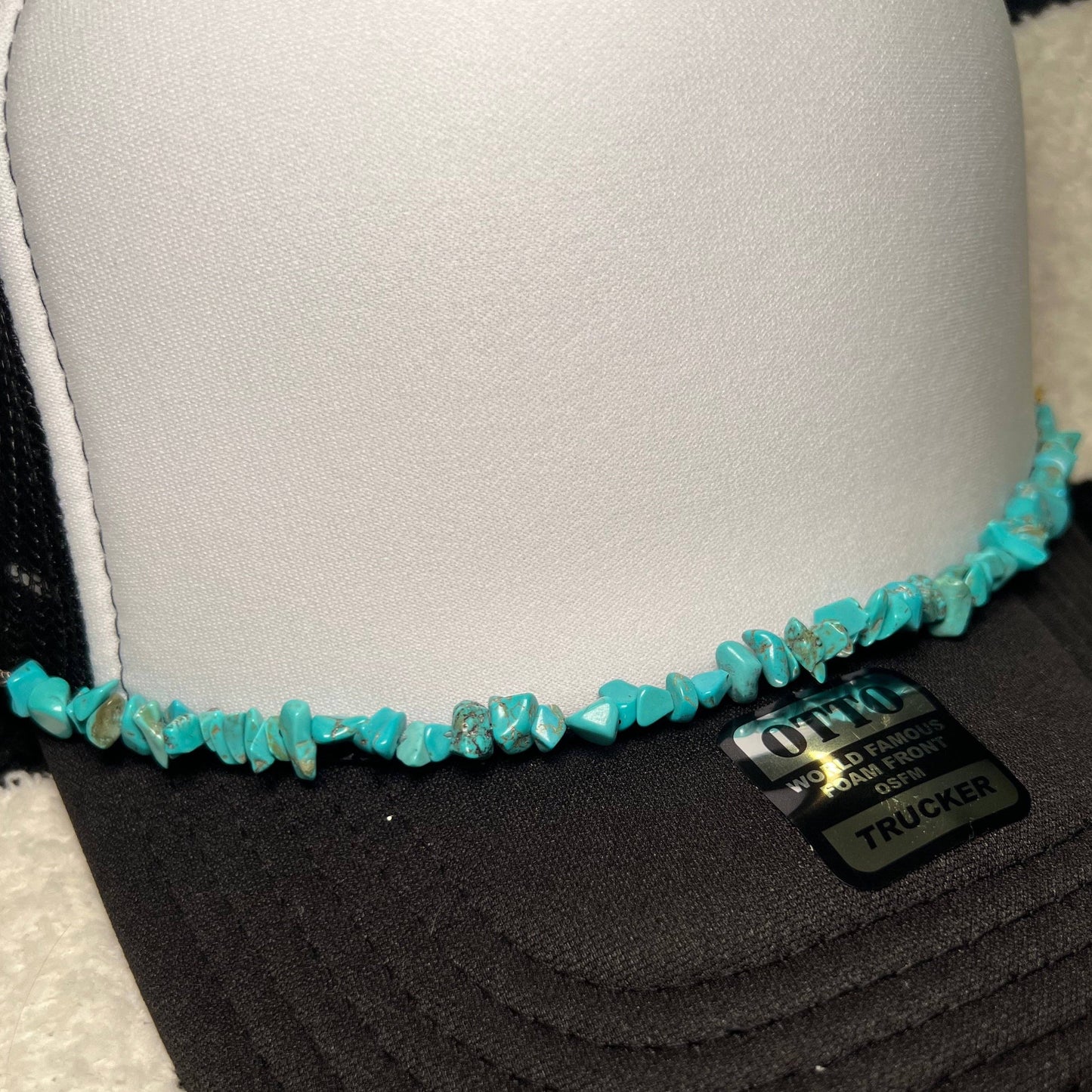 Black and white trucker hat with turquoise stone embellishment.