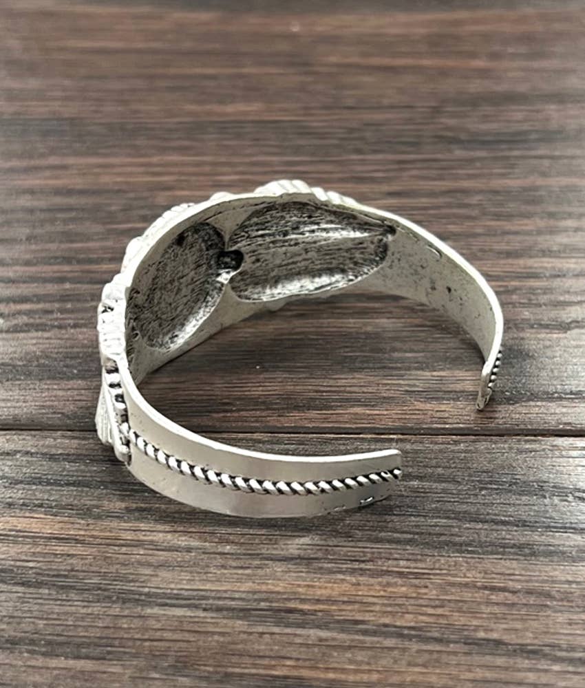 Silver cuff bracelet on wood.