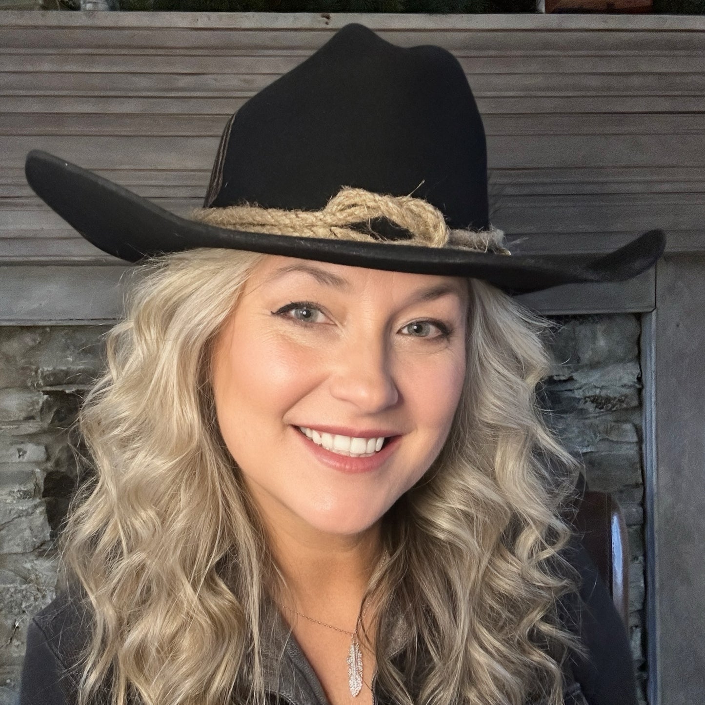 Woman smiling in black cowboy hat