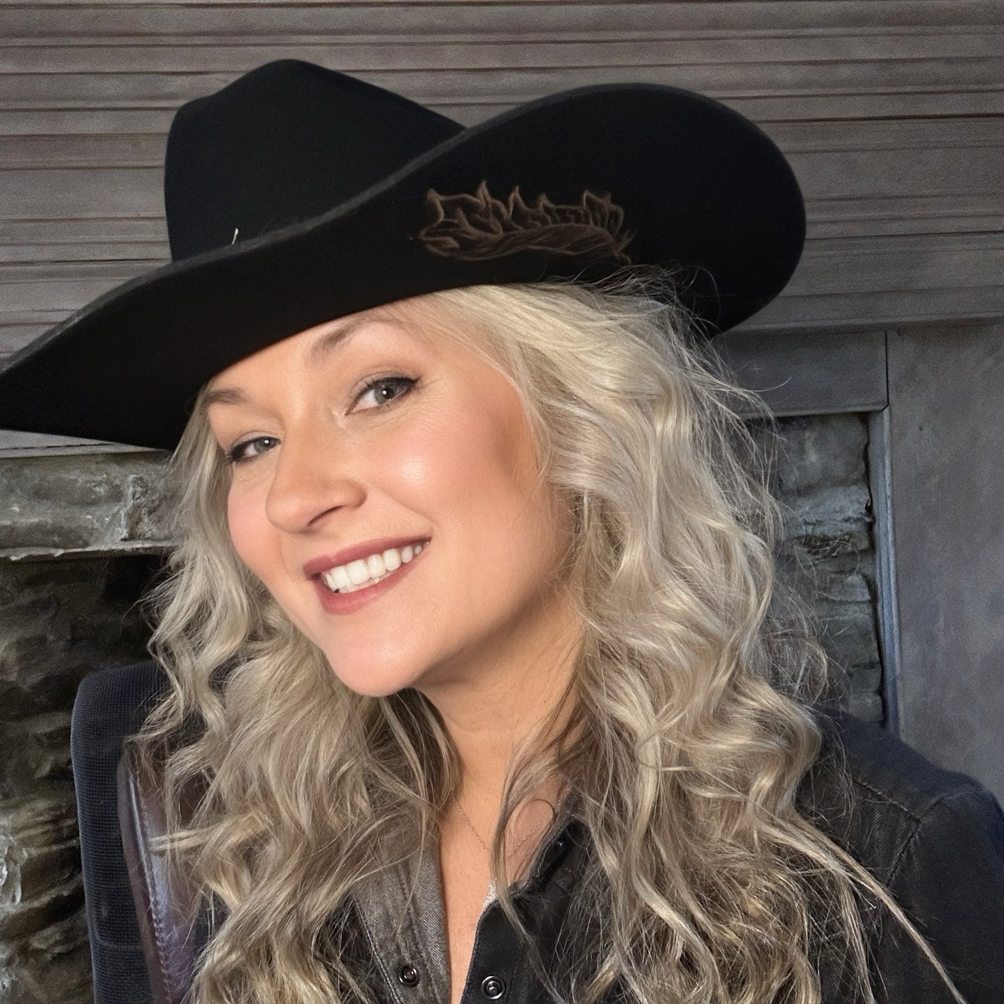 Woman in black cowboy hat smiling
