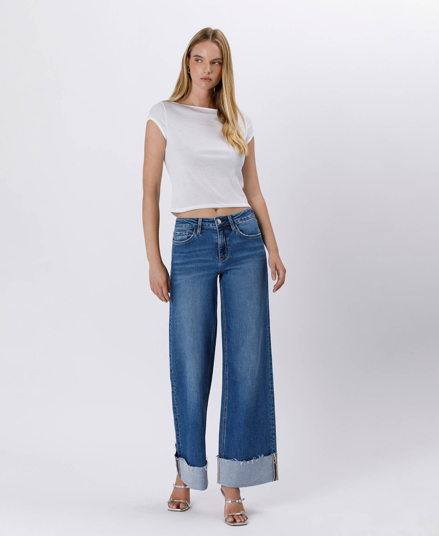 Woman in white top and wide-leg jeans.