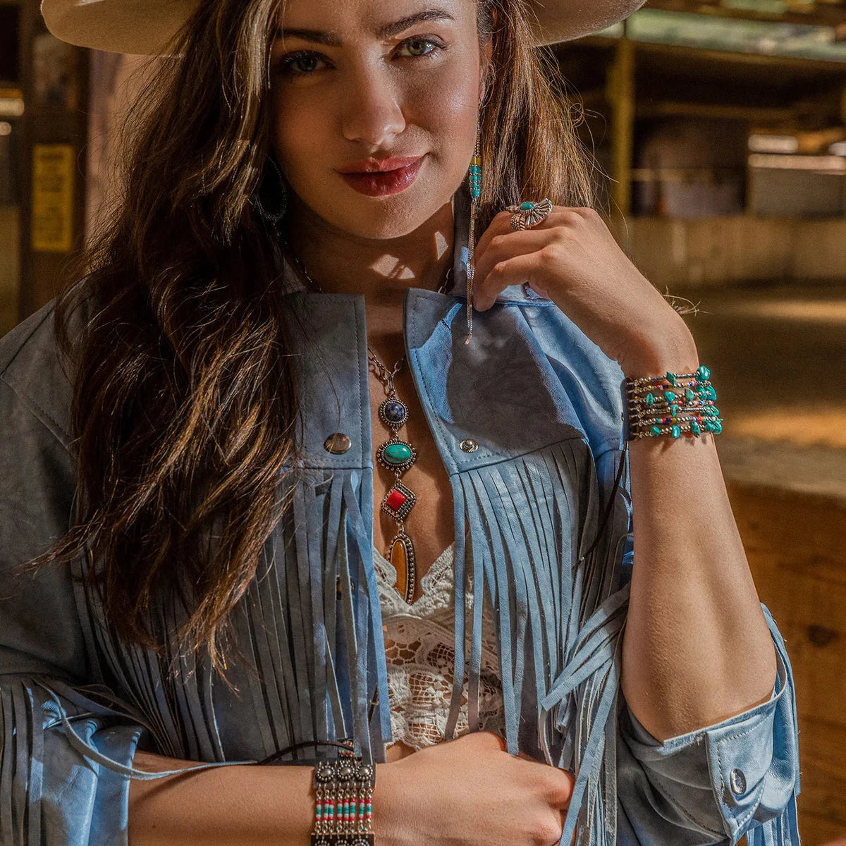 Woman in fringe jacket and jewelry, lifestyle image.