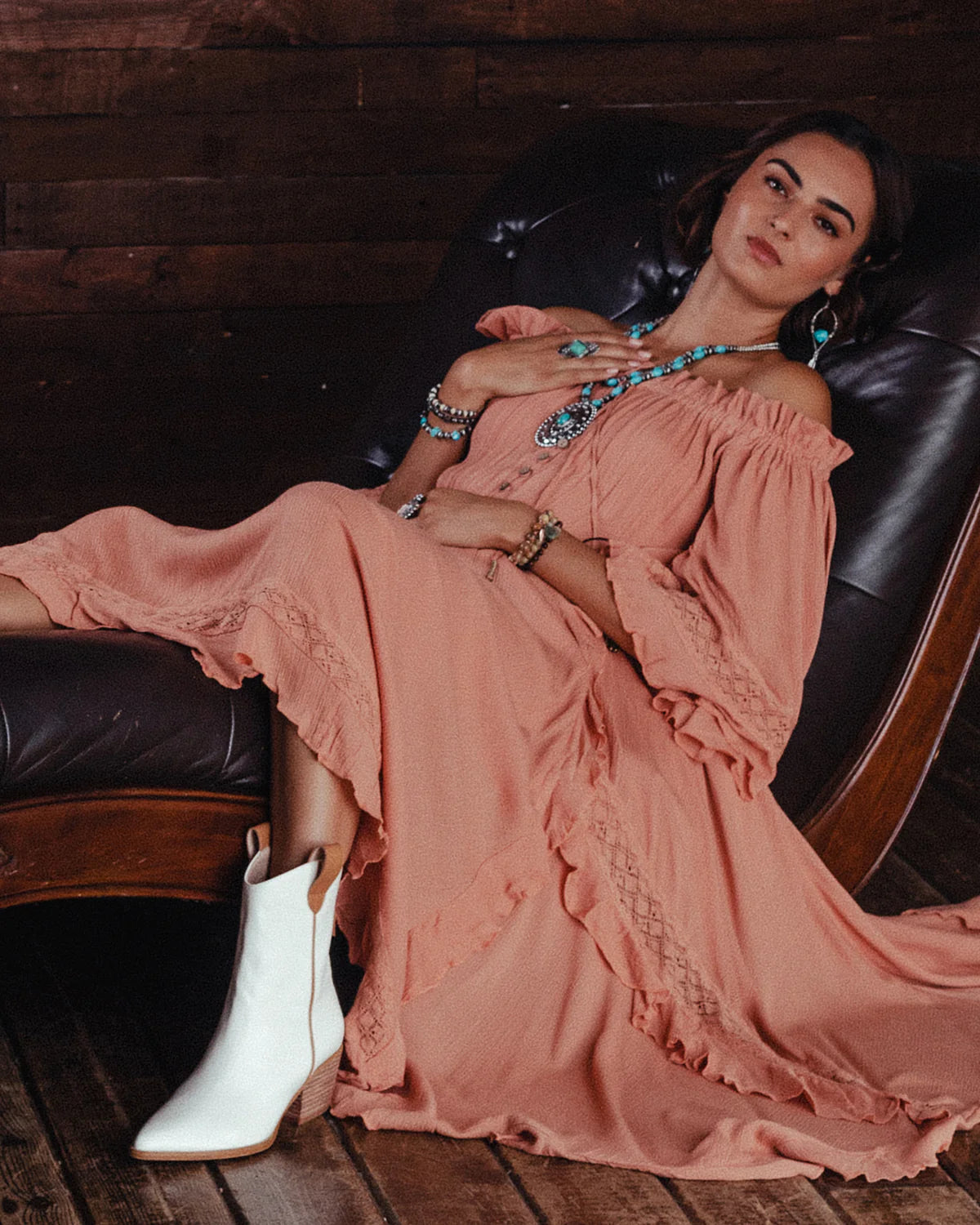 Boho lifestyle image featuring a woman in a pink dress and white boots.
