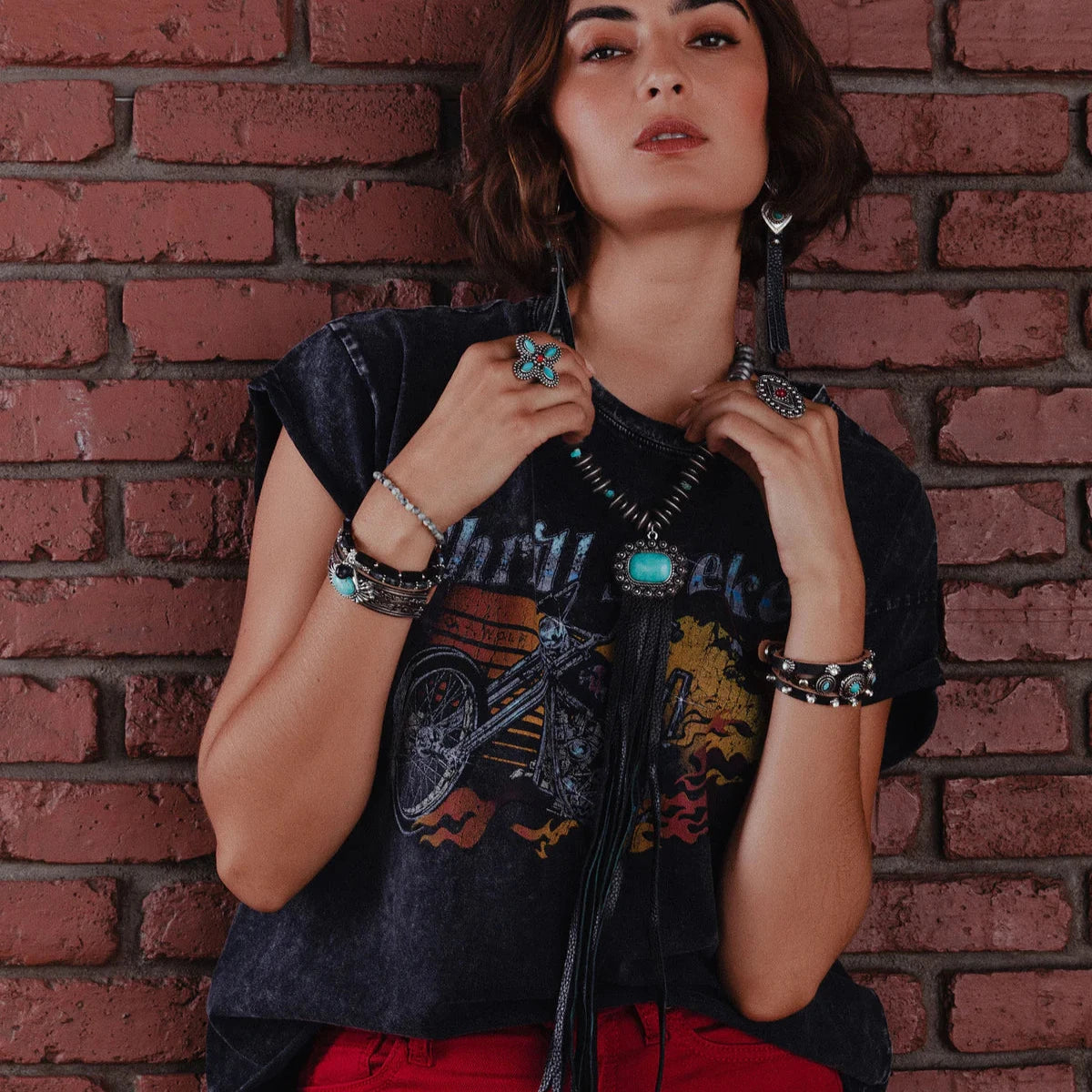 Woman in lifestyle jewelry and graphic tee.