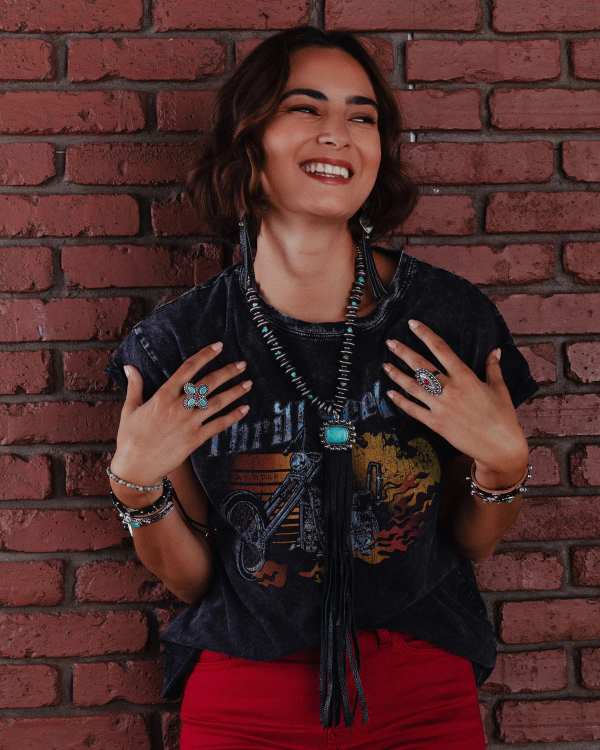 Woman smiling, wearing jewelry and red pants - lifestyle