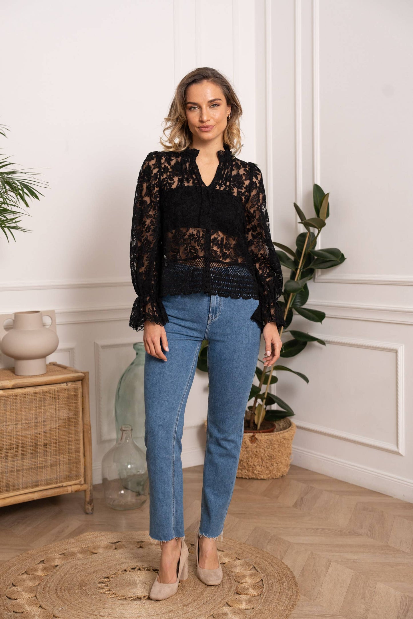 Woman in black lace top and jeans.