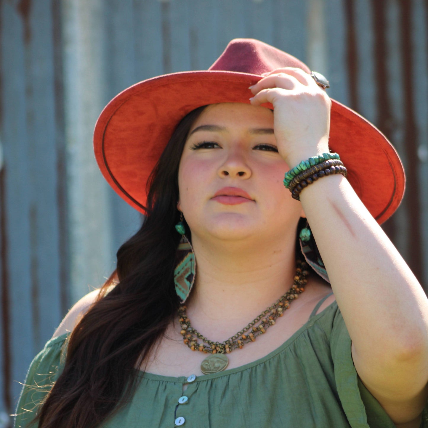 Woman in red hat and green top.