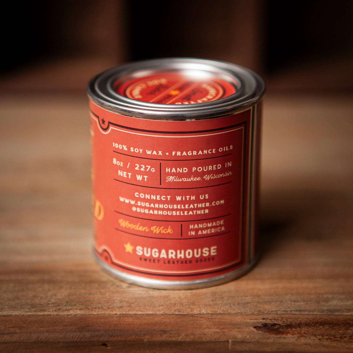 Red candle tin on wood surface.