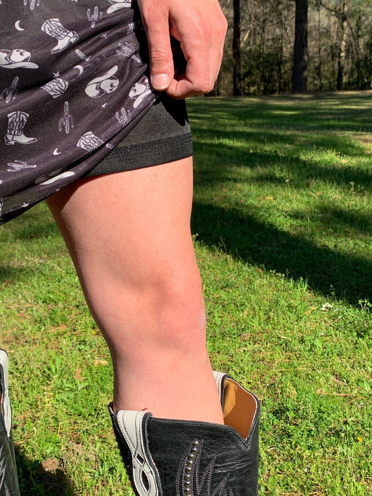 Leg in cowboy boot and skirt.