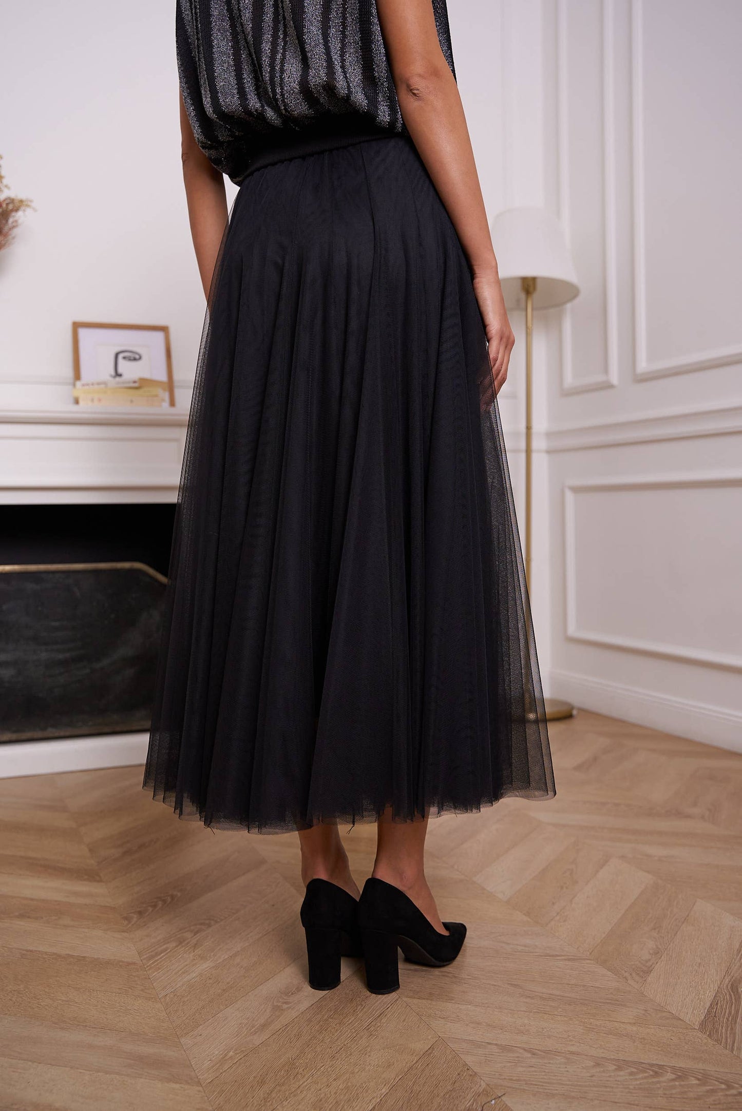 Woman in black tulle skirt and heels.