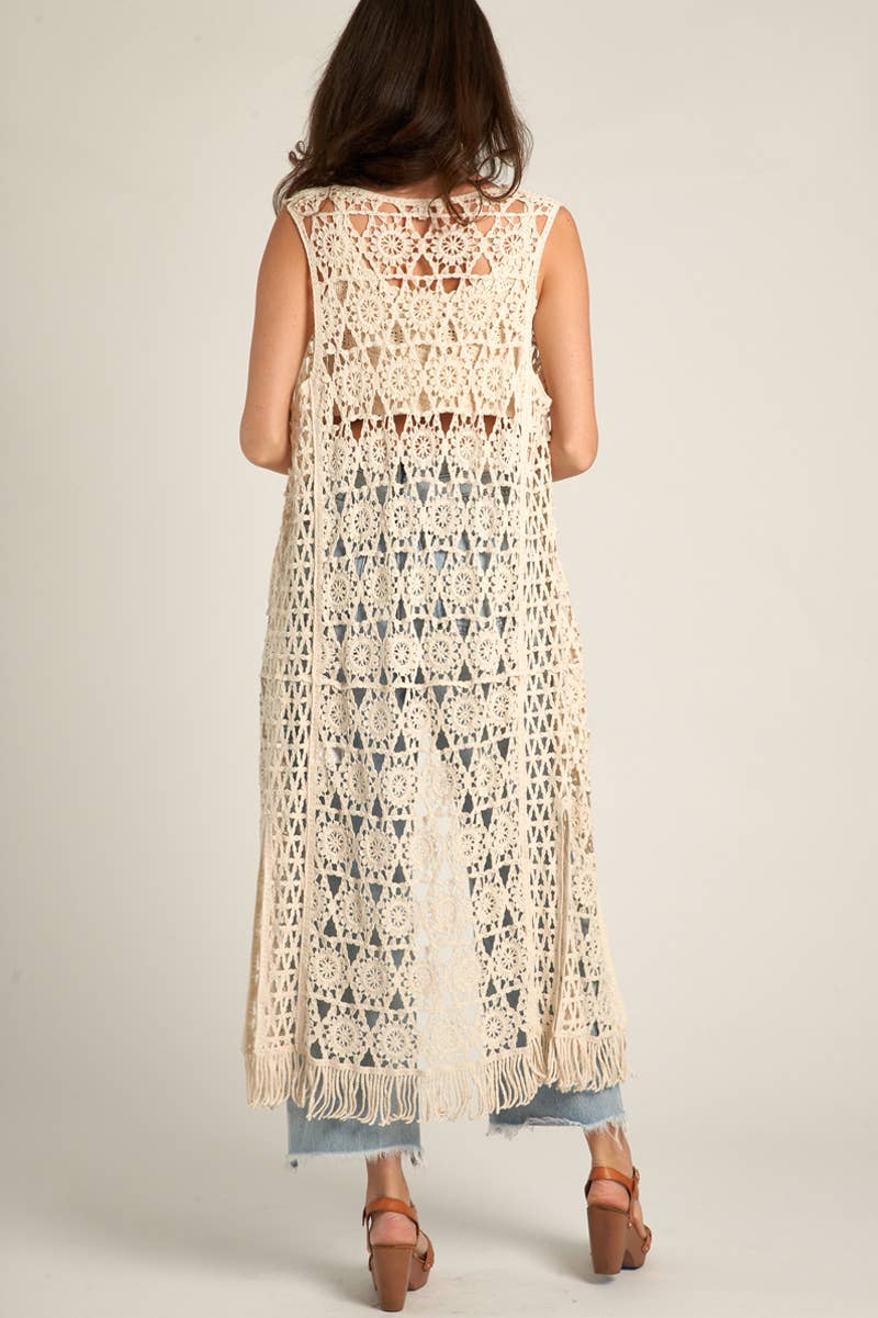 Woman wearing a long, cream-colored crocheted vest.
