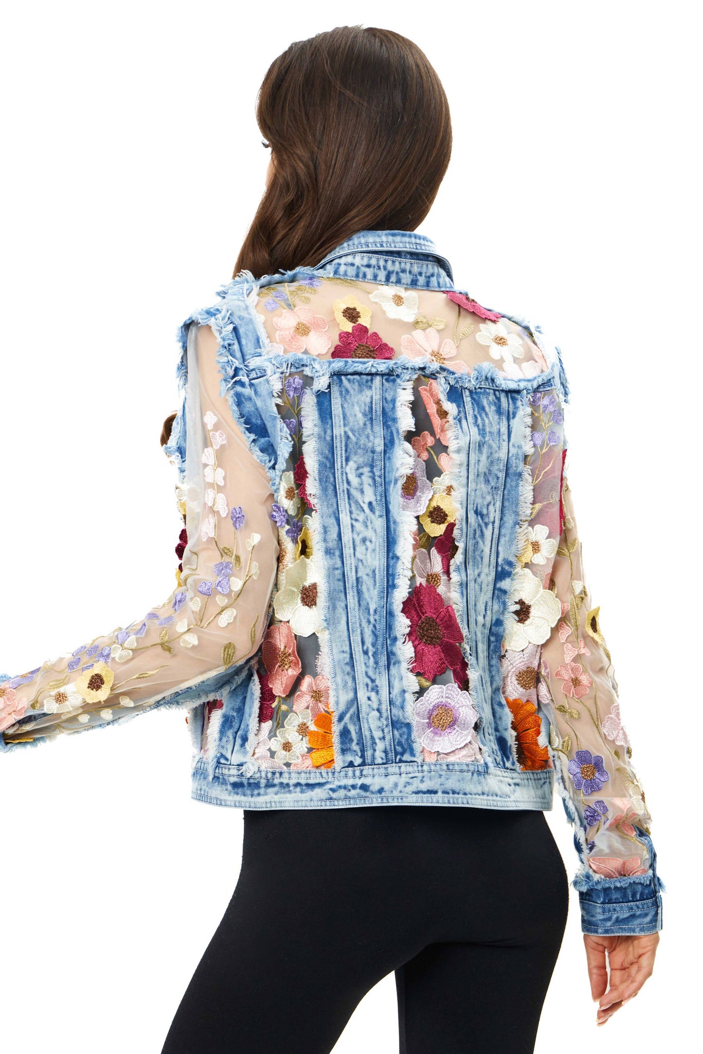 Woman wearing a denim jacket with floral embroidery.